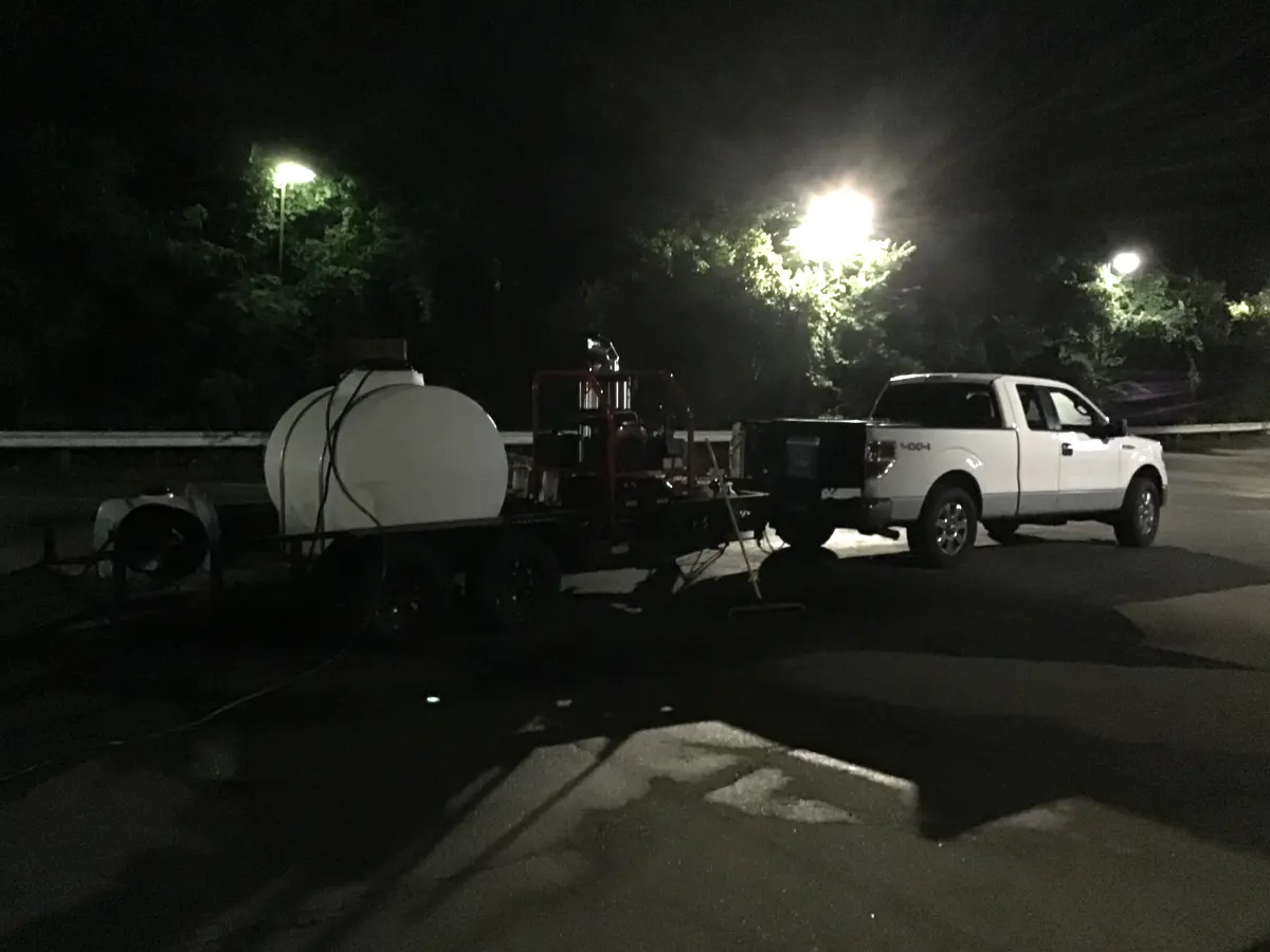 Commercial pressure washing equipment at a nighttime property cleanup